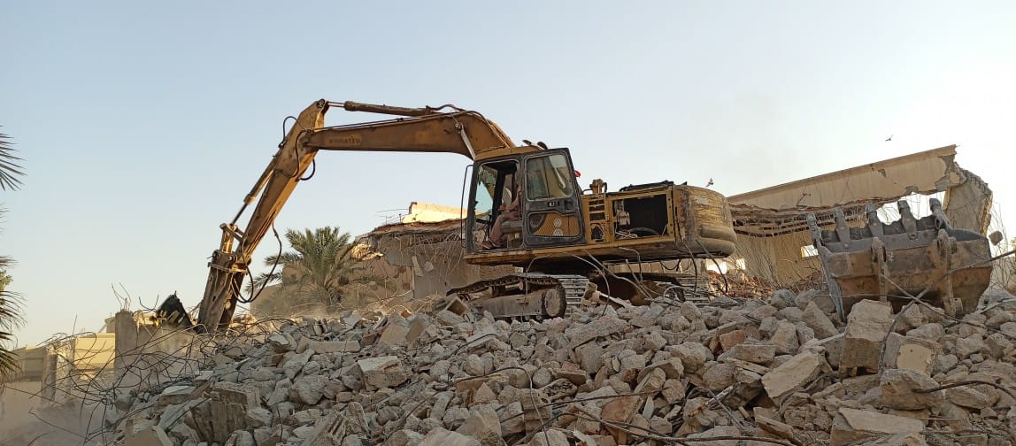 حفارة تعمل وسط أنقاض الهدم